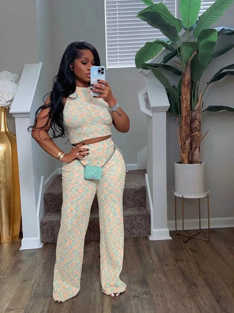 Woman taking a mirror selfie in a patterned outfit in a home setting.